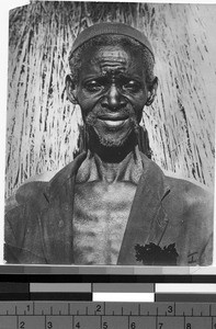 Close-up view of a man standing in front of straw, Rhodesia, Africa, ca. 1920-1950