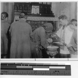 Father Maynard Murphy baptizing a baby at Beitouzhai , China, 1931