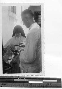 Fr. Kupfer baptizes an orphan at Luoding, China, 1937