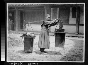 Man carrying portable stoves, China, ca.1920-1930