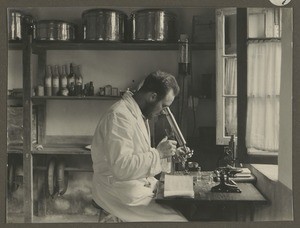 Mission deacon Nüßler using microscope, Tanzania, ca.1929-1940