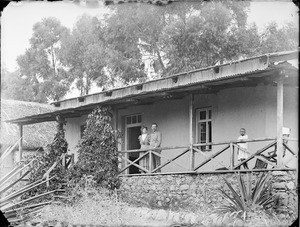 Missionary Augustiny and wife and African boy on a veranda, Tanzania, ca.1902-1912
