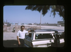 man beside a house and automobile