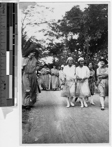 Three Maryknoll Sisters walking with a group of student nurses, Los Banos, Philippines, January 7, 1928