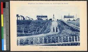 Two men standing on a fence-lined road near a wooden church, Canada, ca.1920-1940