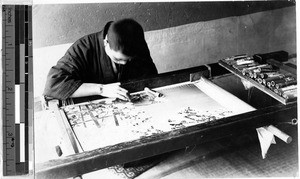 Japanese man embroidering a piece of silk, Japan, ca. 1920-1940