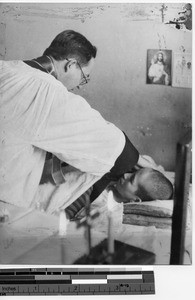 Fr. Escalante annointing a dying child in Fushun, China, 1938