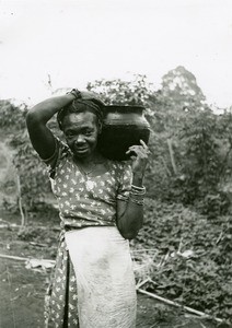 Woman carrying water, in Ebeigne, Gabon