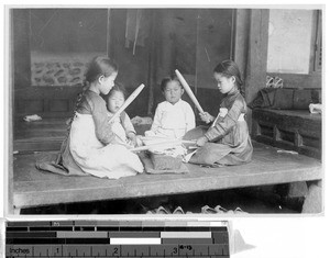 Two girls ironing with sticks, Korea, ca. 1920-1940