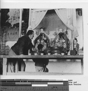 Fr. Tennien and child view pagan idols in Wuzhou, China