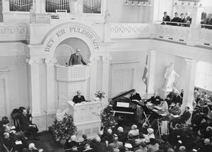 Landsmødet i Aarhus i maj 1952. DMS på bredere folkekirkelig basis, var tema for pastor H. P. Madsens vægtige indlæg til debat om hjemmearbejdet: og der blev lyttet. Seminarieforstander rektor Paul Holt på dirigentstolen