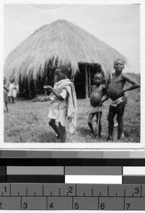 Children outside standing near a hut , Africa, March 1948