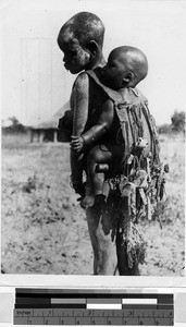 Boy carrying a baby on his back, Belgian Congo, Africa, April 1947