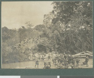 Carriers crossing a stream, Cabo Delgado, Mozambique, August 1918