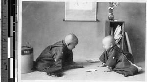 Two children looking at a piece of paper, Japan, ca. 1920-1940