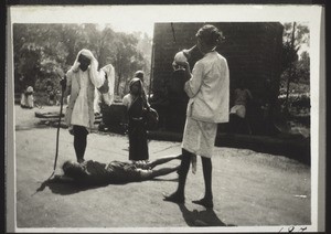 Madastana. A young woman is rolling on the floor. A temple servant plays on a horn made from a shell