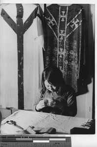 A girl sewing a vestment at Fushun, China, 1940