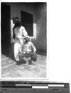 Maryknoll Sister bandages a young mans head at Guilin, China, 1949