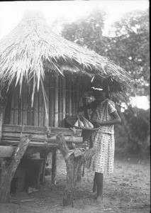 African girl standing next to a storeroom, Ricatla, Mozambique