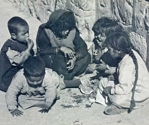 Børn deler en halv appelsin. Foto anvendt 1954Children share half an orange. Photo used 1954