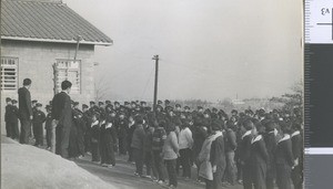 Teachers addressing student beside school building