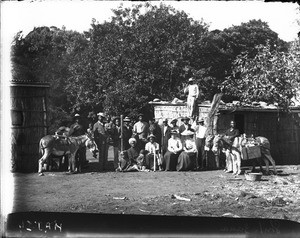 European women and African people in front of buildings with corrugated iron roofs, Shilouvane, South Africa, May 1906