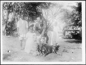 Missionary Blumer, his son Arnold and a group of Africans presenting a shot antelope, Arusha, Tanzania, ca. 1925-1930