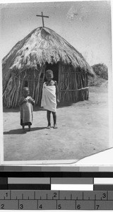 Two children standing outside a hut, Africa, October 1947