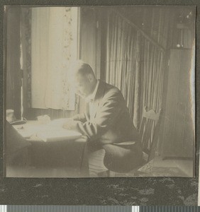 Dr Irvine working at a desk, Tumutumu, Kenya, ca.1921