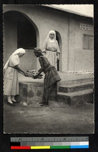 Woman giving bananas to missionary sisters, Cote d'Ivoire, ca.1920-1940