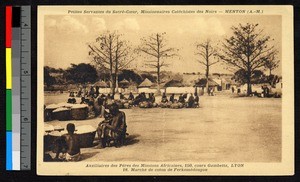 People seated in a market near baskets filled with food, Cote d'Ivoire, ca.1920-1940