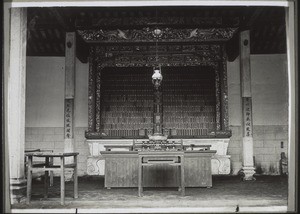 Inneres der Ahnenhalle bei Lyungwo. Ahnenschrein mit Ahnentafel & Altar davor. Die Schnitzereien sind alle vergoldet, ebenso die Namen auf den Tafeln & die Umrahmung derselben