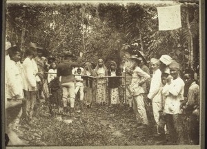 Chopping through the trunk of a tree at a funeral celebration