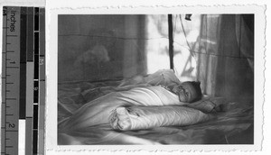 Swaddled baby laying on a bed, Carrillo Puerto, Quintana Roo, Mexico, March 1946