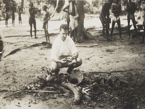 Rev. C Ransome handling embers of idols, Nigeria, 1934