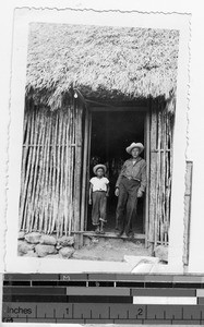 Man and boy standing in the general store doorway, Laguna, Quintana Roo, Mexico, ca. 1944