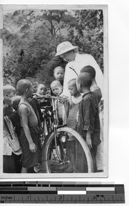 Fr. Arthur Dempsey shows his bike to children in Wuzhou, China, 1938