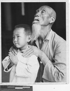 Two people praying at Jiangmen, China, 1944