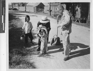 Fr. Paulhus with Chinese man and daughters at Jiangmen, China, 1947