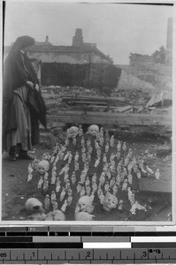 Sister Richard, MM, looking at doll parts stuck in dirt, Yokohama, Japan, ca. 1923