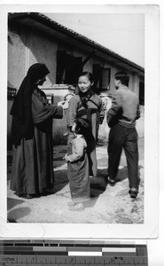 A Maryknoll Sister with a family at Guilin, China, 1949