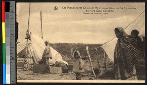 Woman carrying a child on her back standing with others near tents, Canada, ca.1920-1940