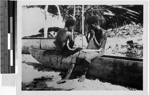 Two boys playing instruments on a canoe, Solomon Islands, Oceania, 1938