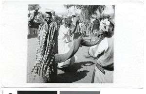 Old woman dancing and man blowing a horn at the coronation celebration, Ramotswa, Botswana, 1937