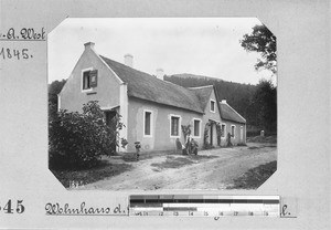 Four people in front of a house, Genadendal, South Africa