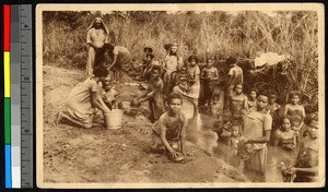 Women and children preparing foodstuffs by a stream bank, Congo, ca.1920-1940