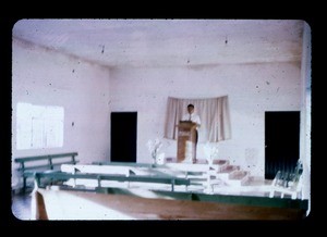 Man inside church building standing behind a pulpit, likely Iglesia de Cristo in Mexico