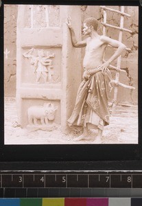 Man and bas-reliefs on walls of royal palace, Abomey, Benin, ca. 1925-26