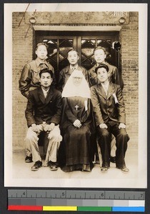 Missionary sister seated with five young Chinese men, China, ca.1940-1945