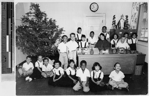 Sister Gladys Green, MM, sitting in her office with children, Punahou, Honolulu, Hawaii, ca.1932-1948